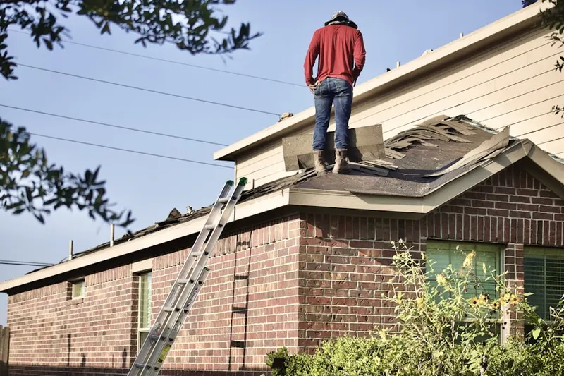 Professional roofer working on a residential roof in Almont